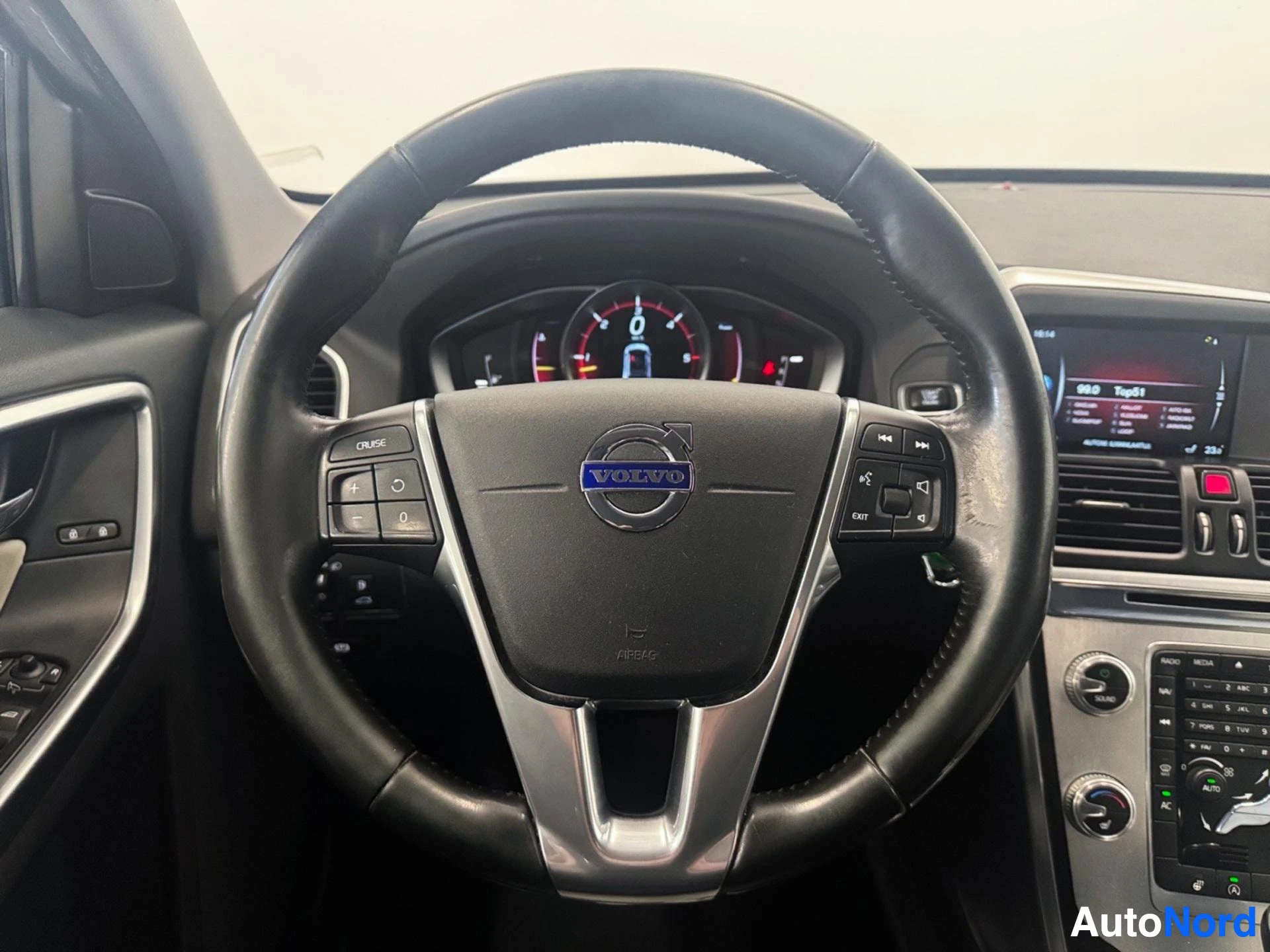 Volvo steering wheel with logo, dashboard and instrument cluster visible