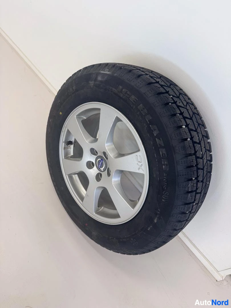 Volvo-merkillinen valkea alumiinivanne mustalla talvikumilla