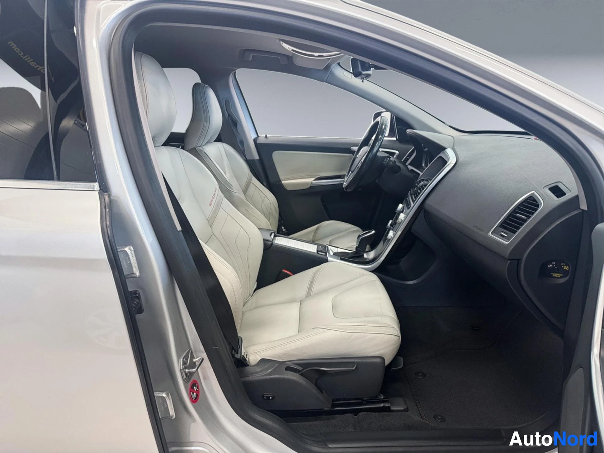 Valkoinen Volvo XC60, sisustanäkymä kuljettajalla ja oikealla puolella, vaaleat istuimet