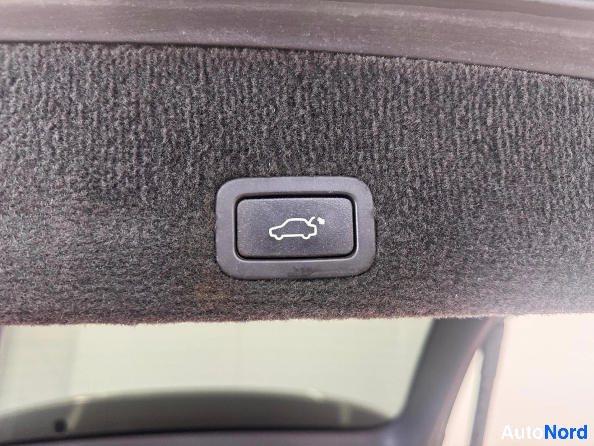 Harmaa kangasmatto auton sisällä automaattisella lukitusnäppäimellä