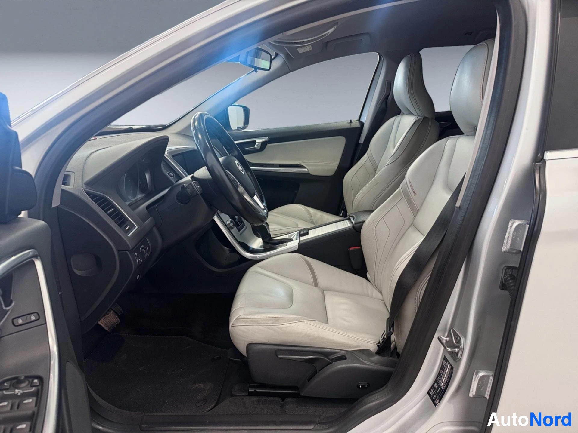 Valkoinen Volvo XC60, avoin kuljettajan ovi, vaaleat nahkaisten istuimet, musta ratti