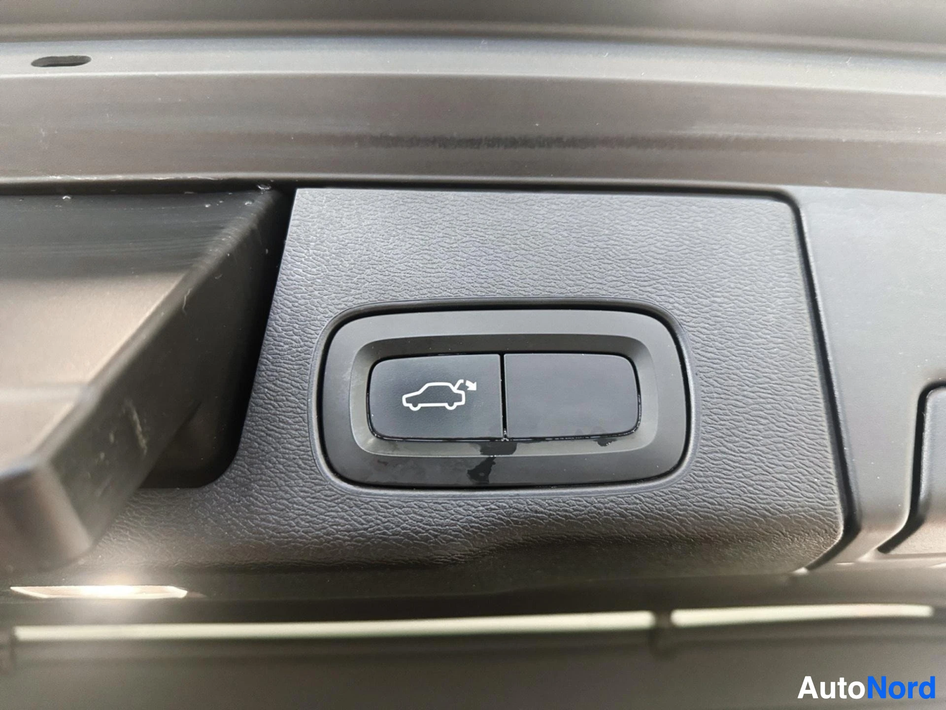 Cargo hatch release button with car icon on dashboard panel
