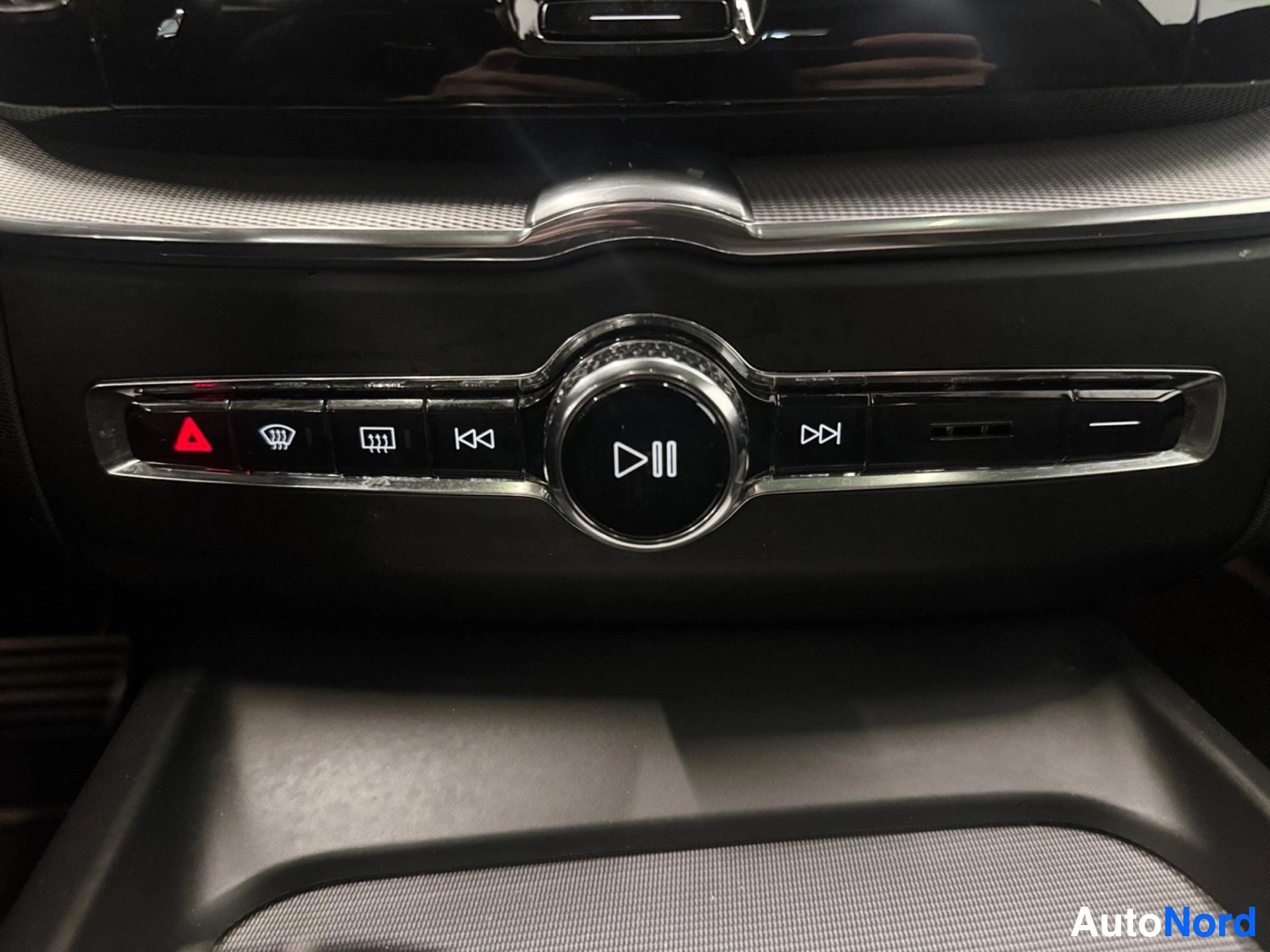 Media control buttons and circular play button on center console