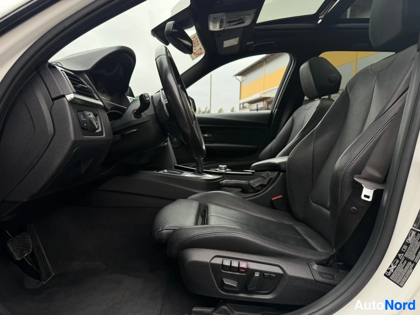 Black leather interior with steering wheel and dashboard visible from driver's side.