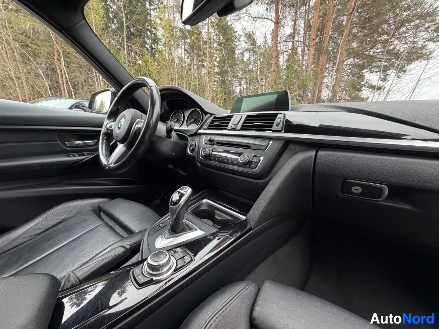Dashboard with infotainment screen, steering wheel, and leather seats from driver's perspective.