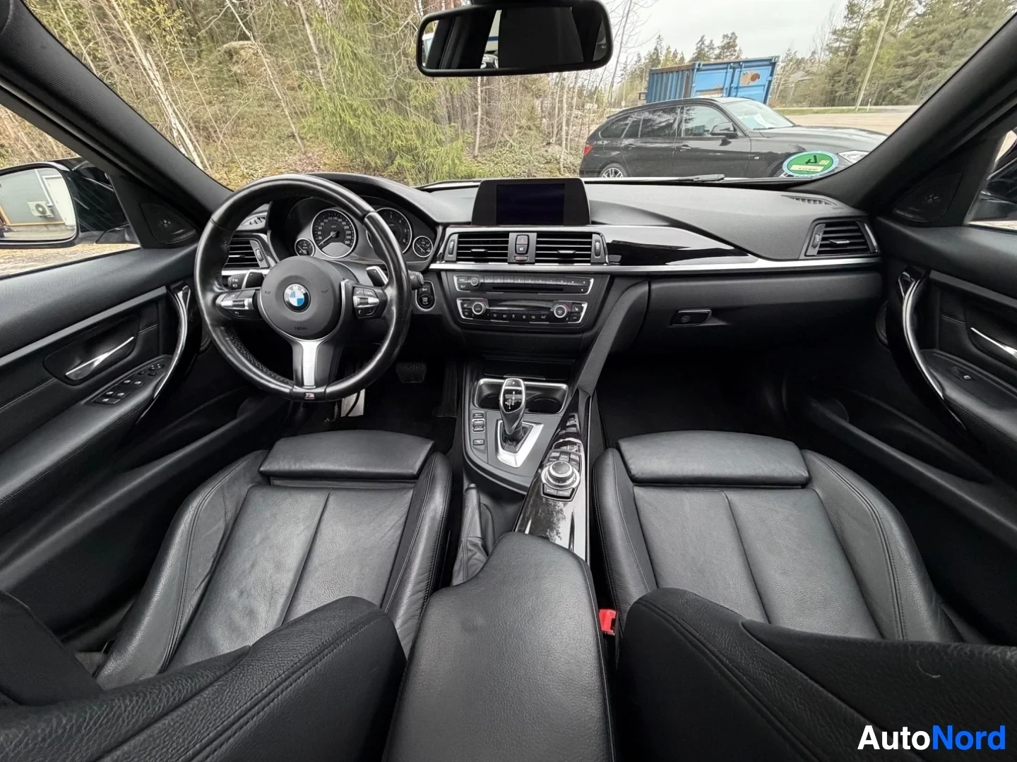 Full interior view from front showing steering wheel, dashboard, and leather seats.