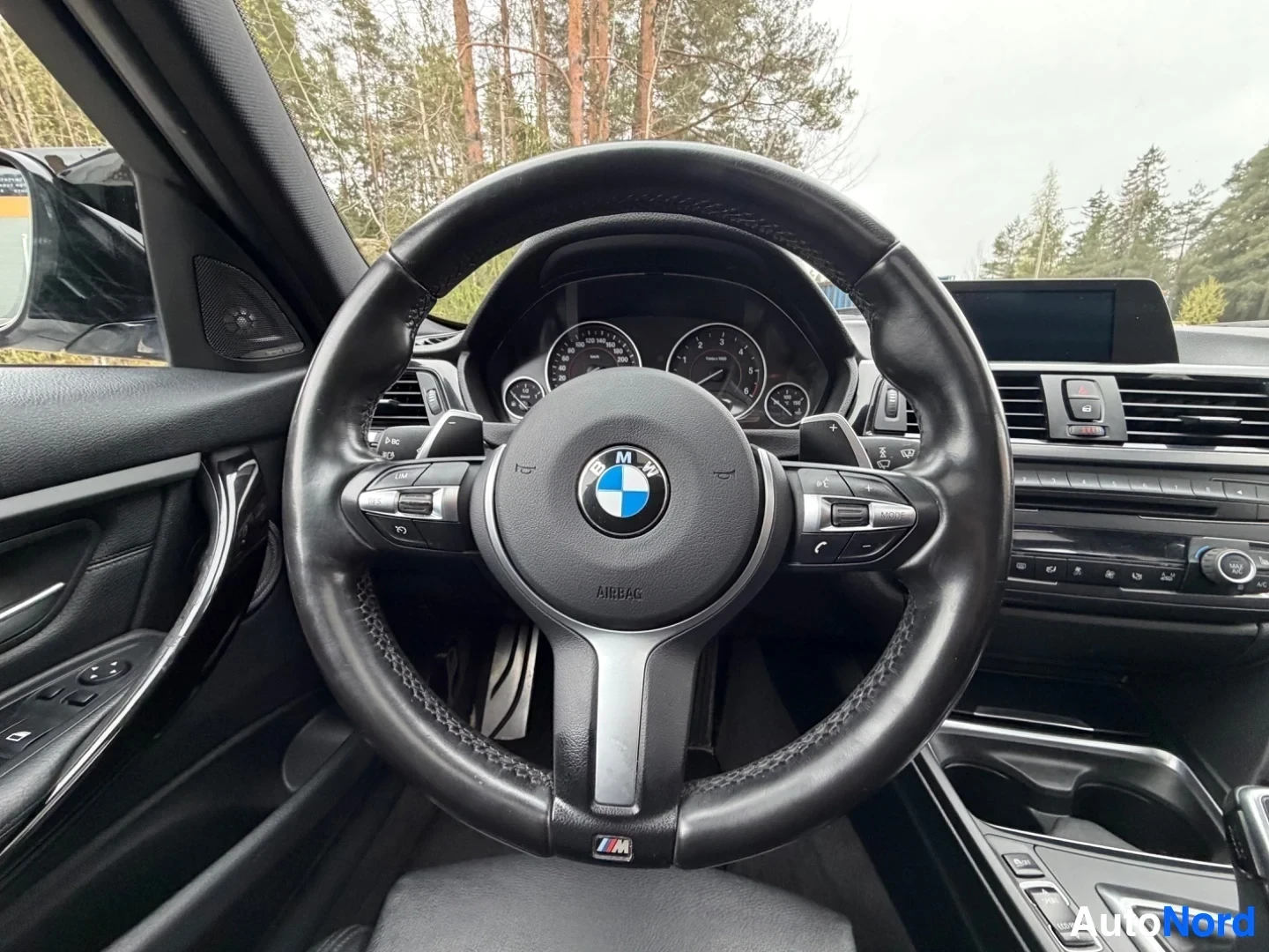 BMW steering wheel with leather and M-Sport trim visible on dashboard