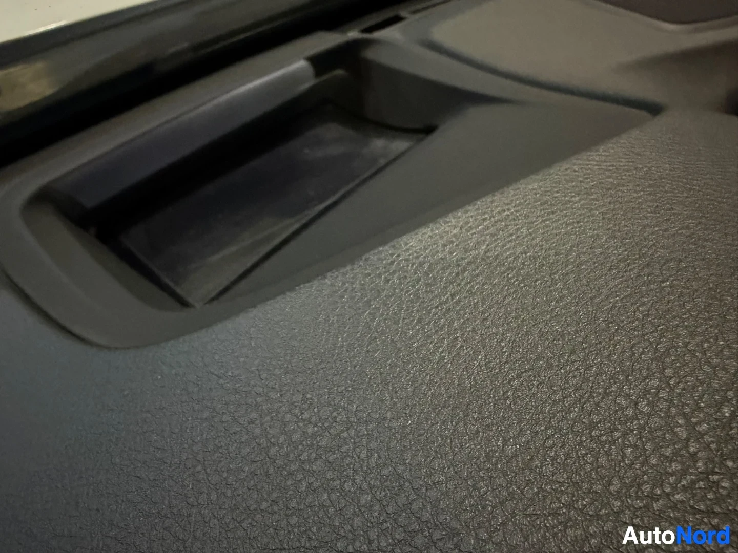 Beige fabric dashboard and door panel with vent opening.