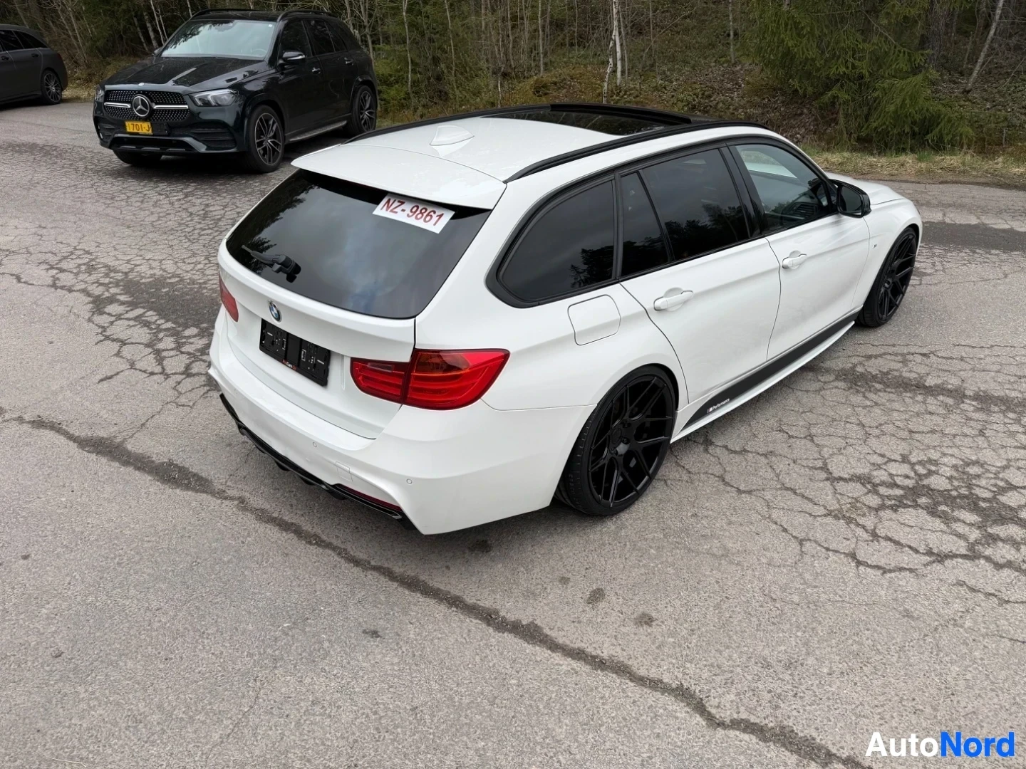 White BMW estate car rear three-quarter view in parking area