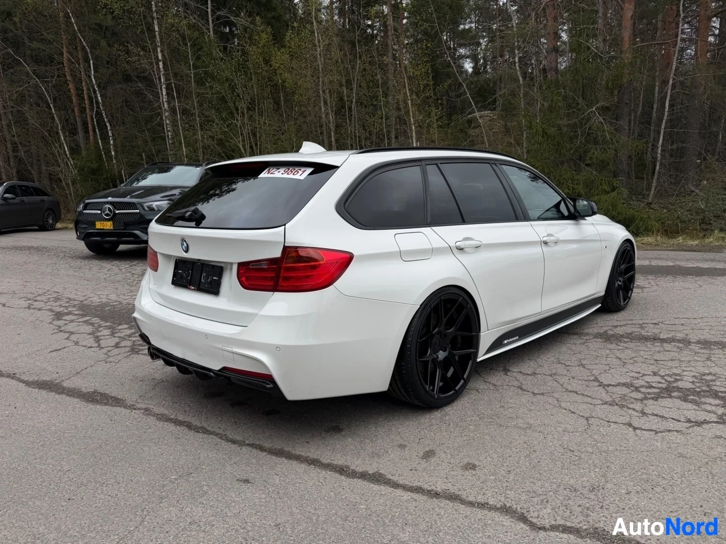 White BMW estate car rear three-quarter view with dark wheels parked outdoors