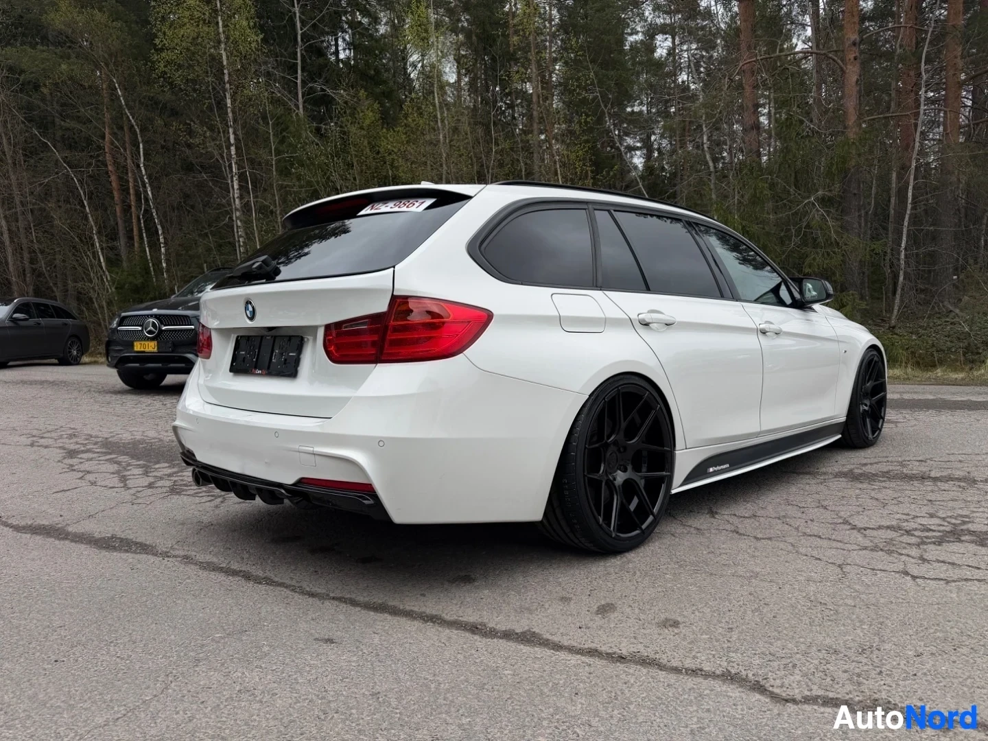 White BMW estate car rear three-quarter view with black alloy wheels from side angle
