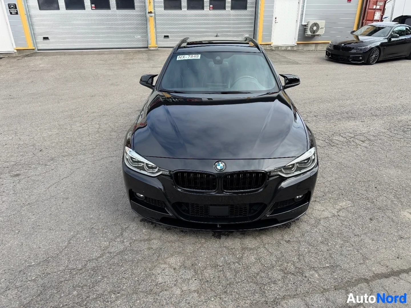 Black BMW station wagon front view in parking lot