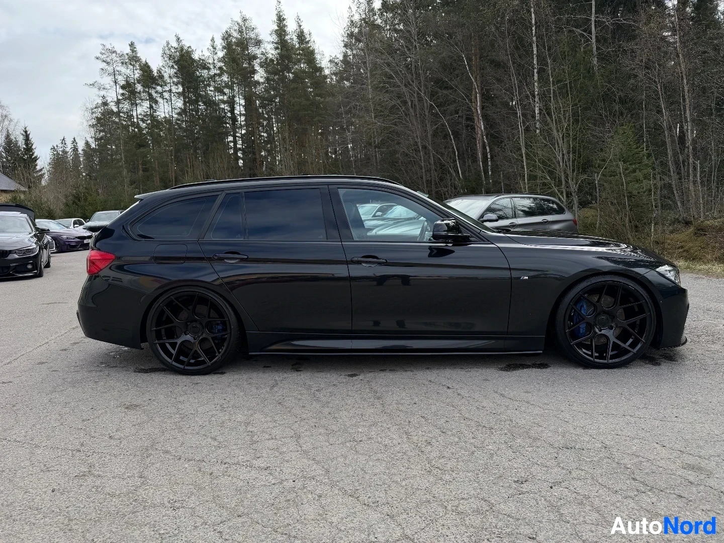 Musta BMW farmari kuvattu sivusta vasemmalta puolelta parkkipaikalla