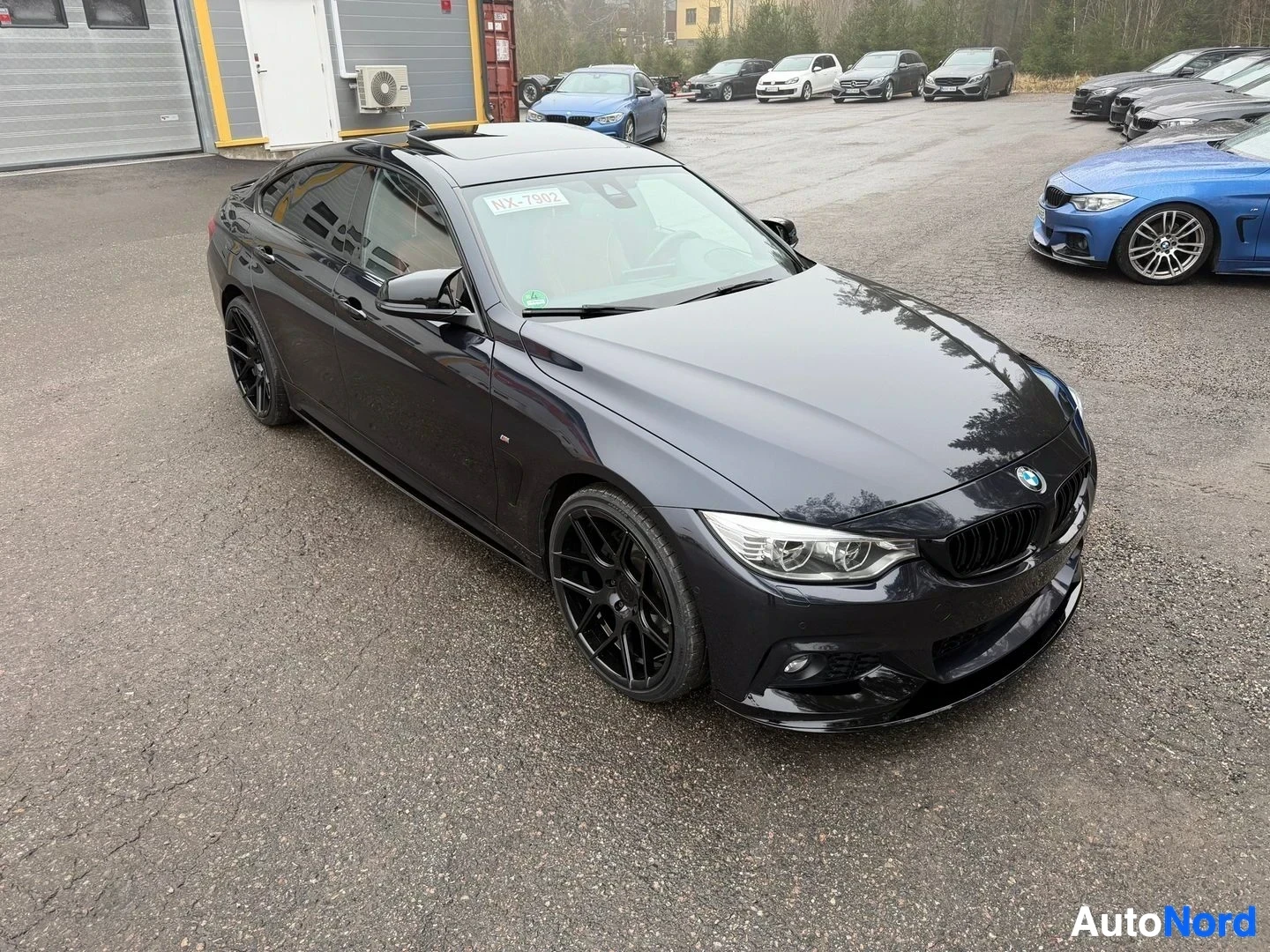 Black BMW coupe photographed from front-left angle in parking lot