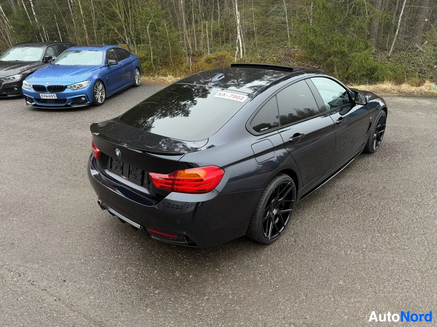 Musta BMW coupe takanäkymässä, punaisia takavaloja ja mustat vanteet