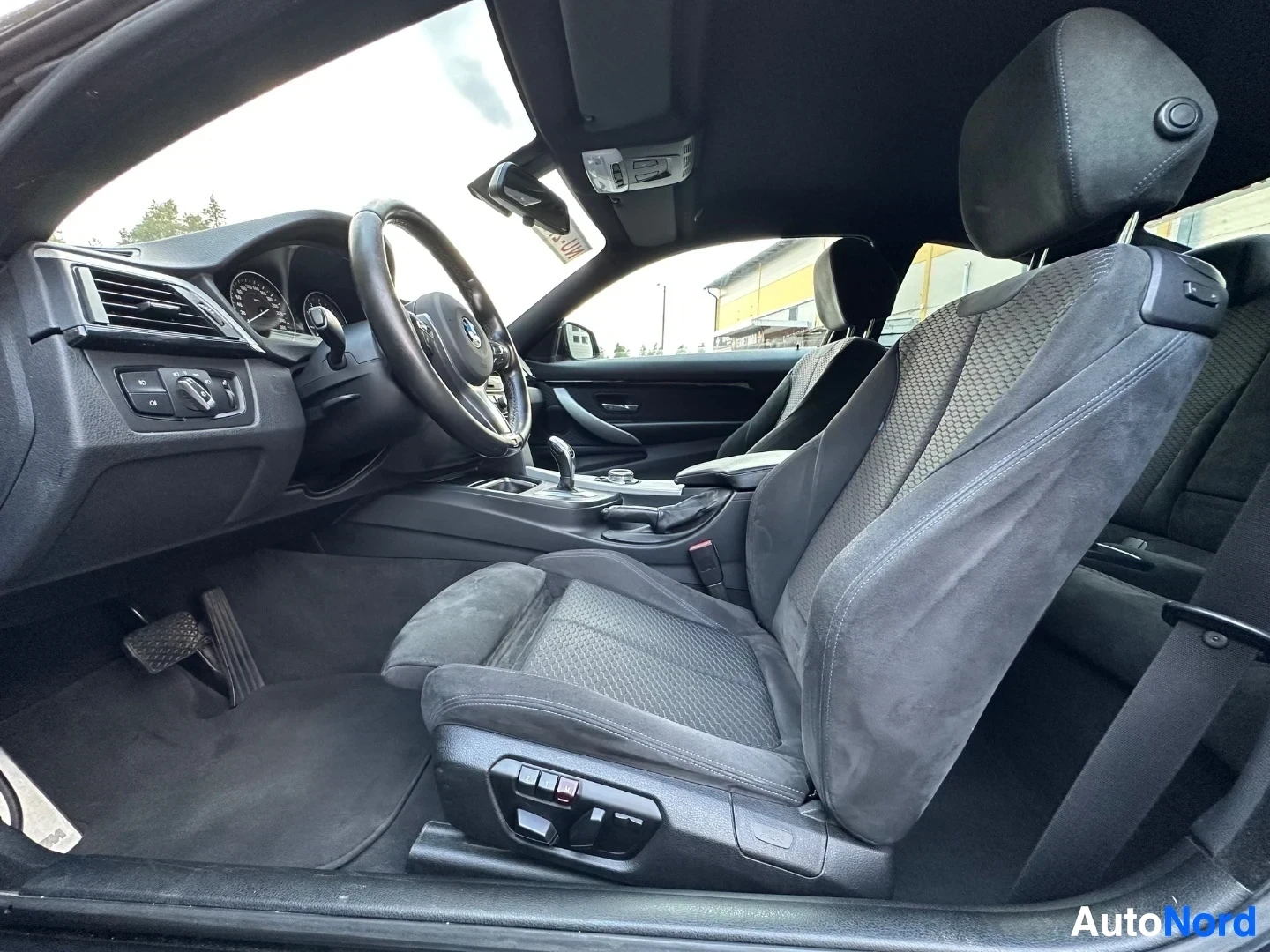 Interior cabin showing driver's seat, steering wheel, dashboard and windshield view