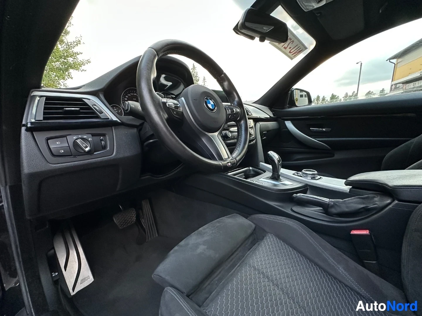 Steering wheel, dashboard controls and center console viewed from driver's perspective