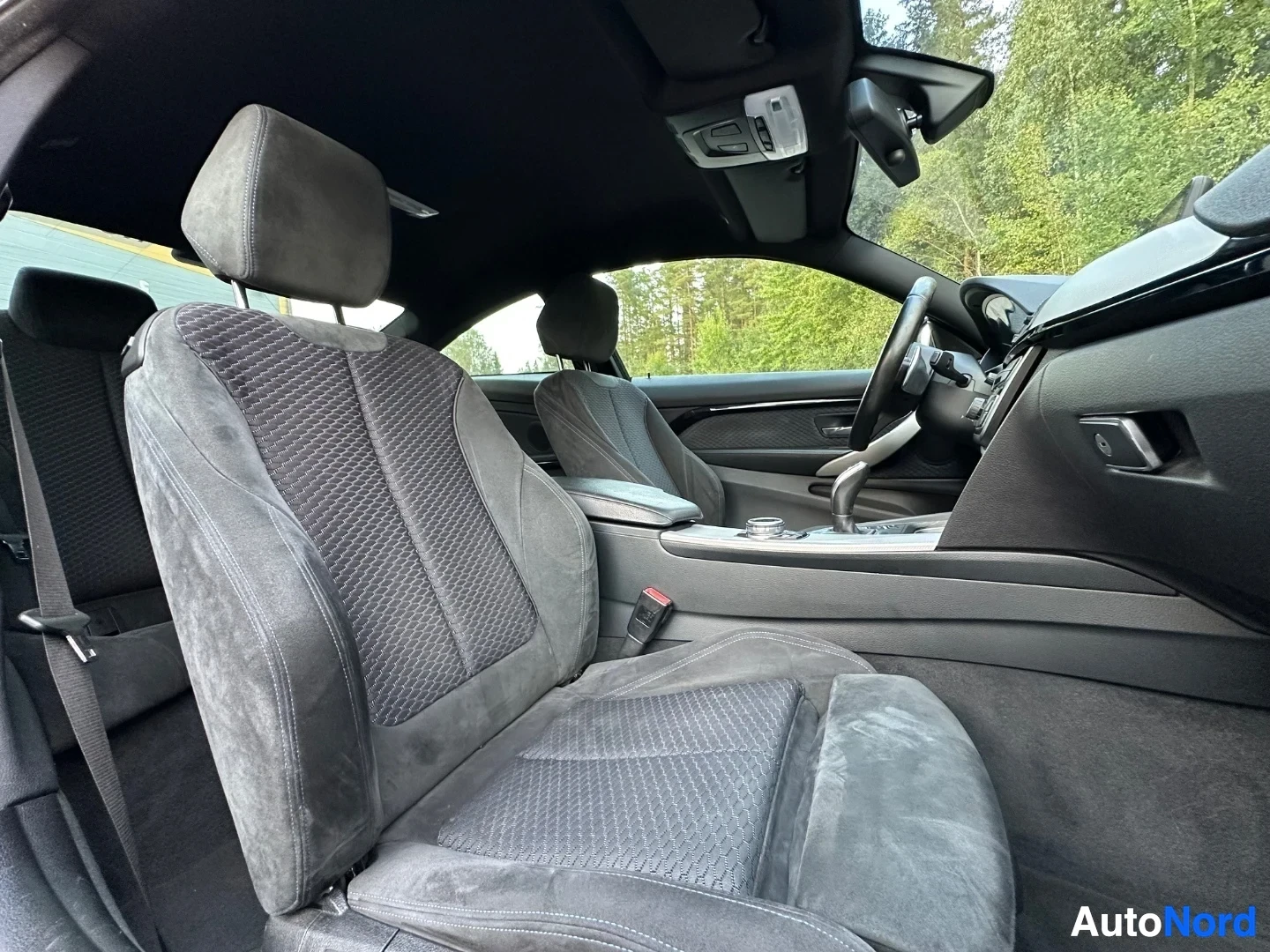 Interior side view of front seats with dashboard and infotainment display visible