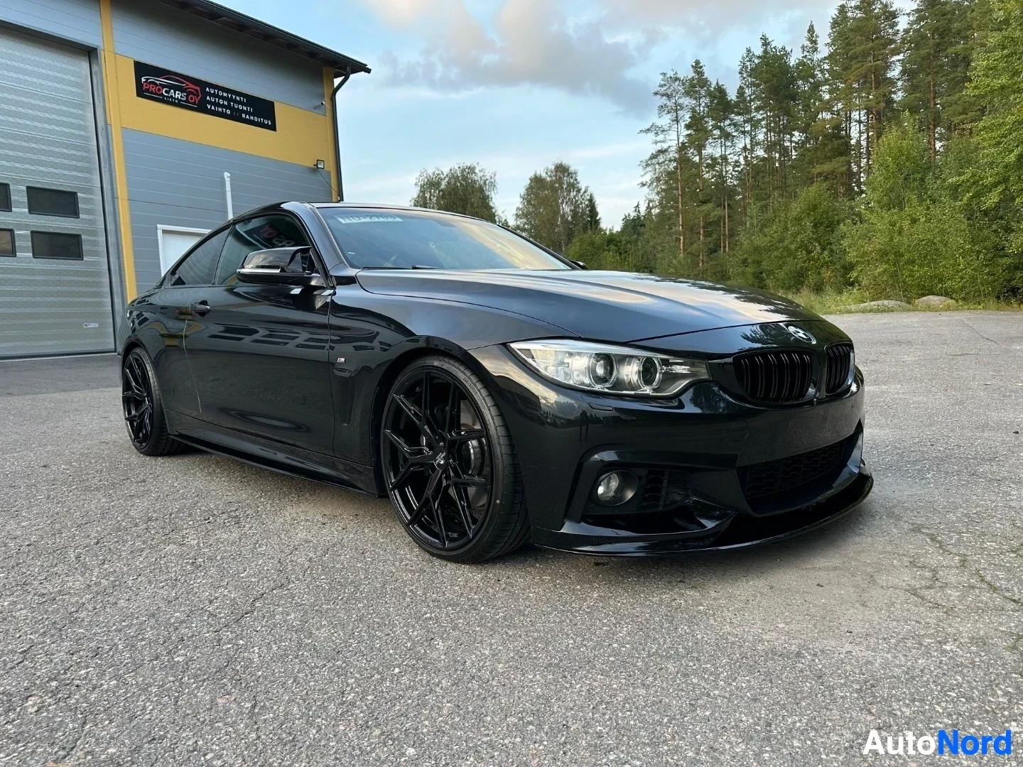 Black BMW coupe front angle view showing kidney grille, headlights, and lower front bumper