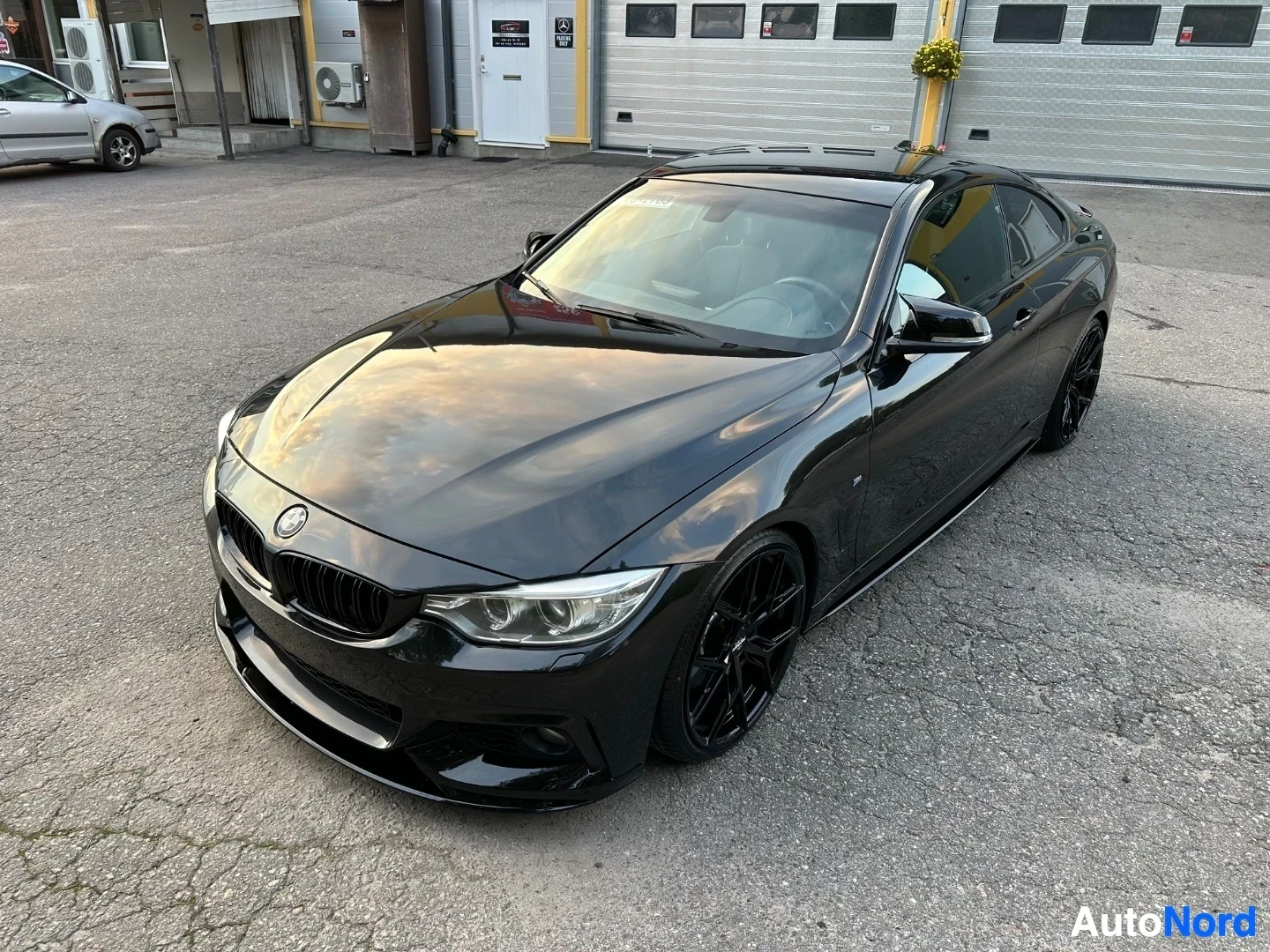 Black BMW coupe photographed from above at high angle outdoors