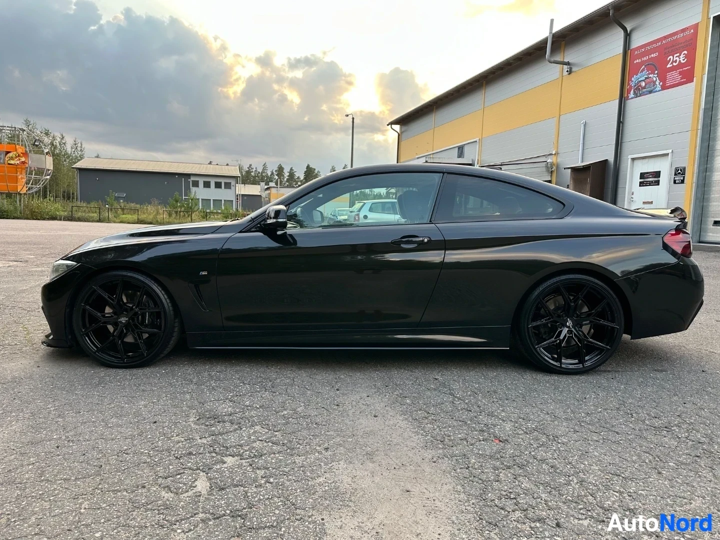 Black coupe shown from driver's side profile in parking lot