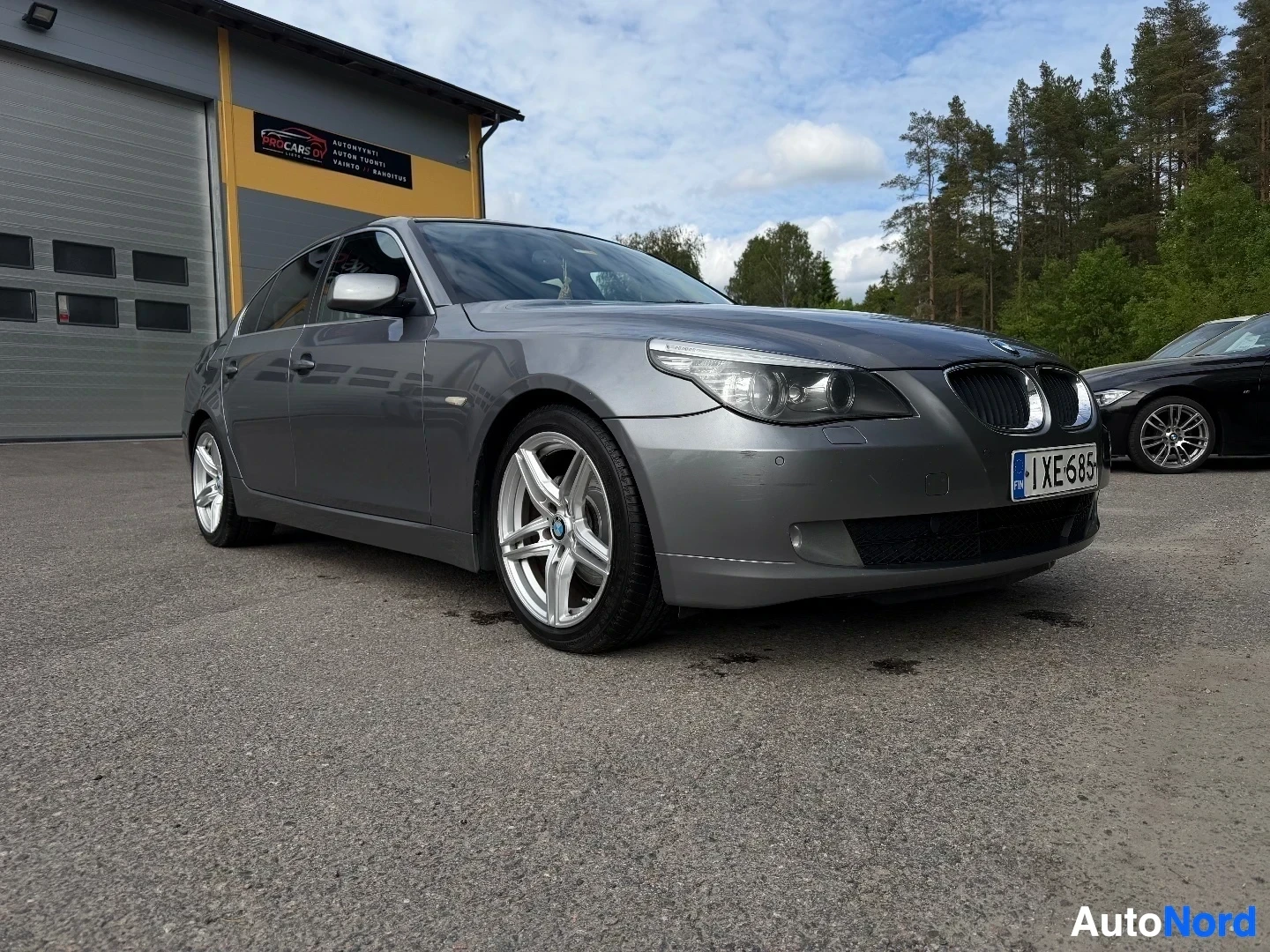 Harmaa BMW sedan sivusta kuvattuna, näkymä vasemmalta puolelta