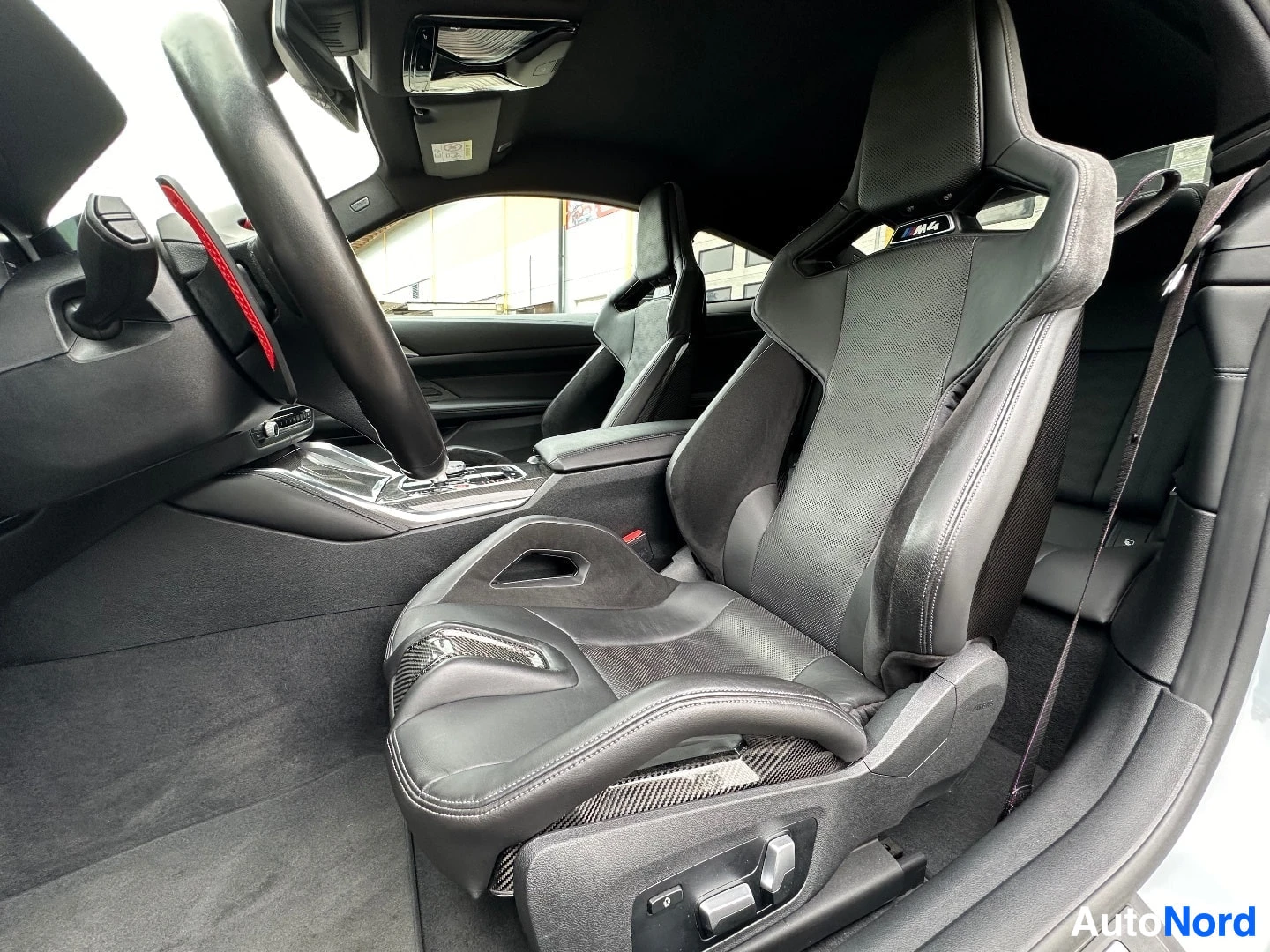 Interior view showing black sport seats with carbon fiber accents and steering wheel