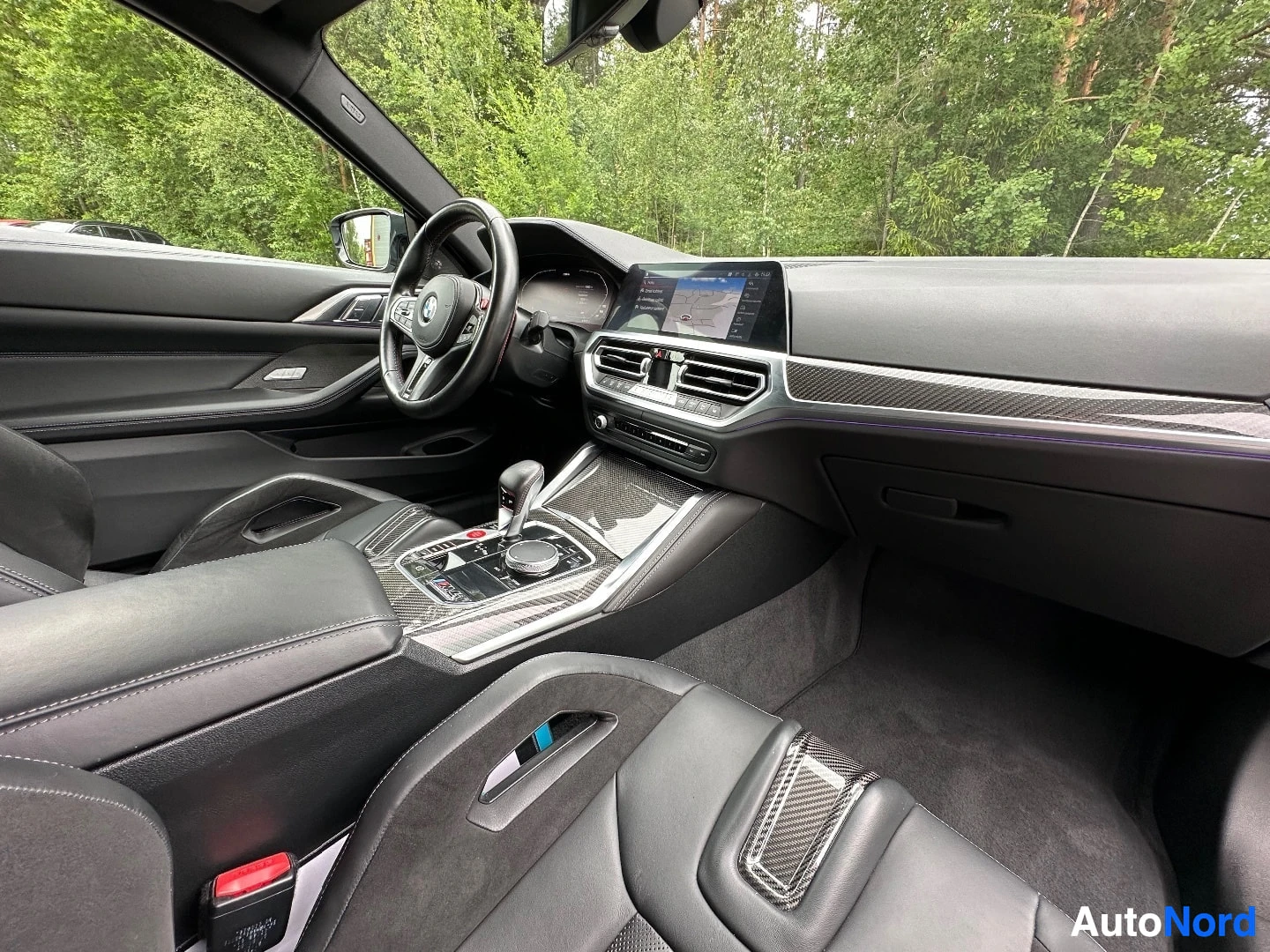 Interior cabin view showing dashboard, steering wheel, and center console from driver side