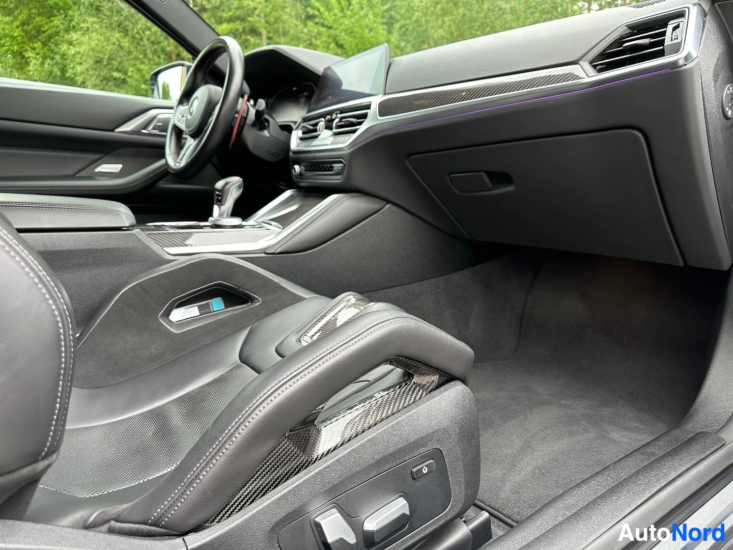 Interior passenger compartment with carbon fiber trim and sport seats visible