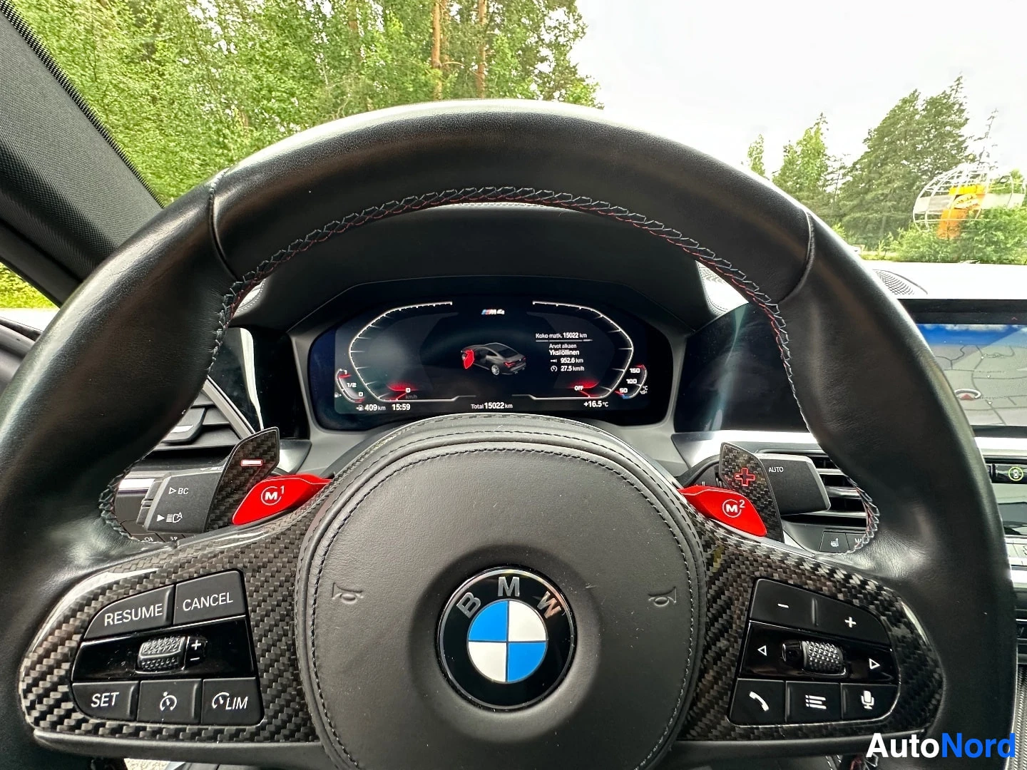 BMW M steering wheel with carbon fiber trim and digital instrument cluster