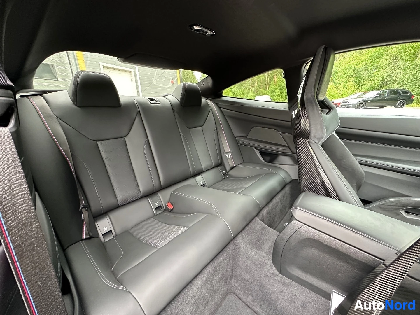 Rear seats with black leather upholstery and carbon fiber trim details