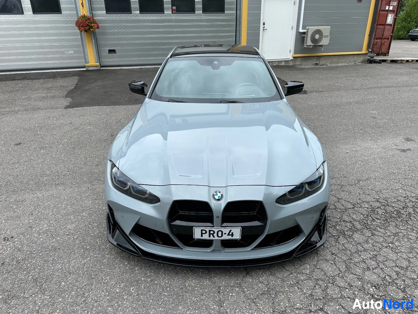 White BMW coupe viewed from front, parked in lot with black grille and dark headlights visible