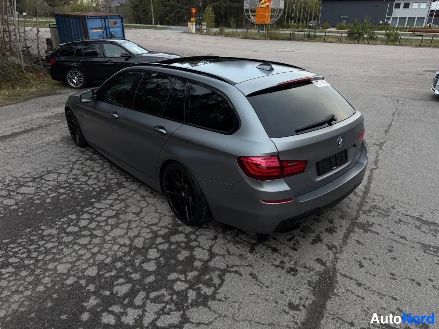 Harmaa BMW farmari sivusta takaapäin näkymä pysäköintialueella