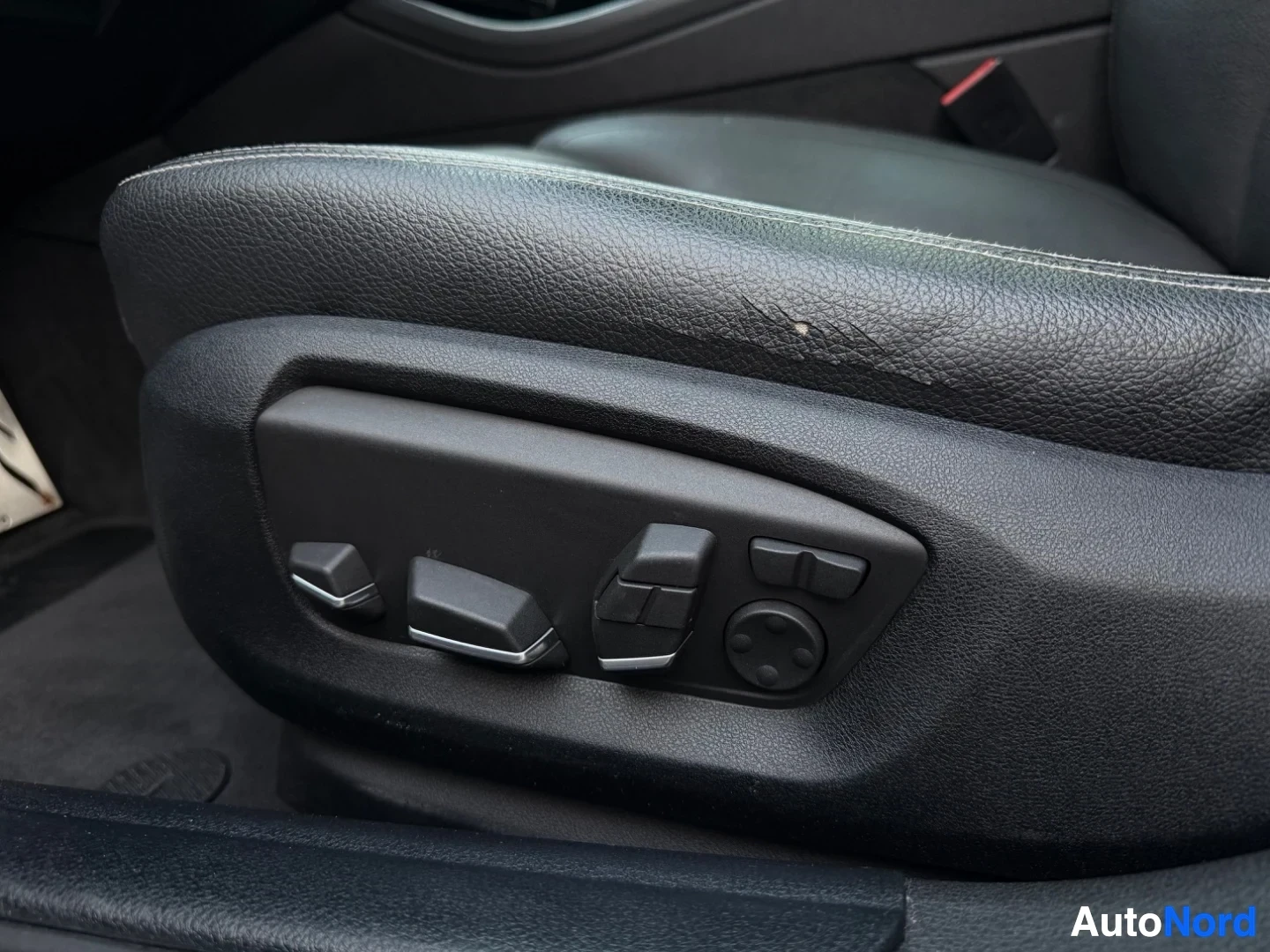 Driver seat with leather upholstery and electric adjustment buttons