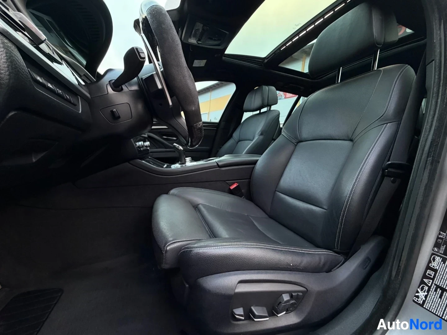 Front interior cabin with steering wheel, seats and panoramic sunroof