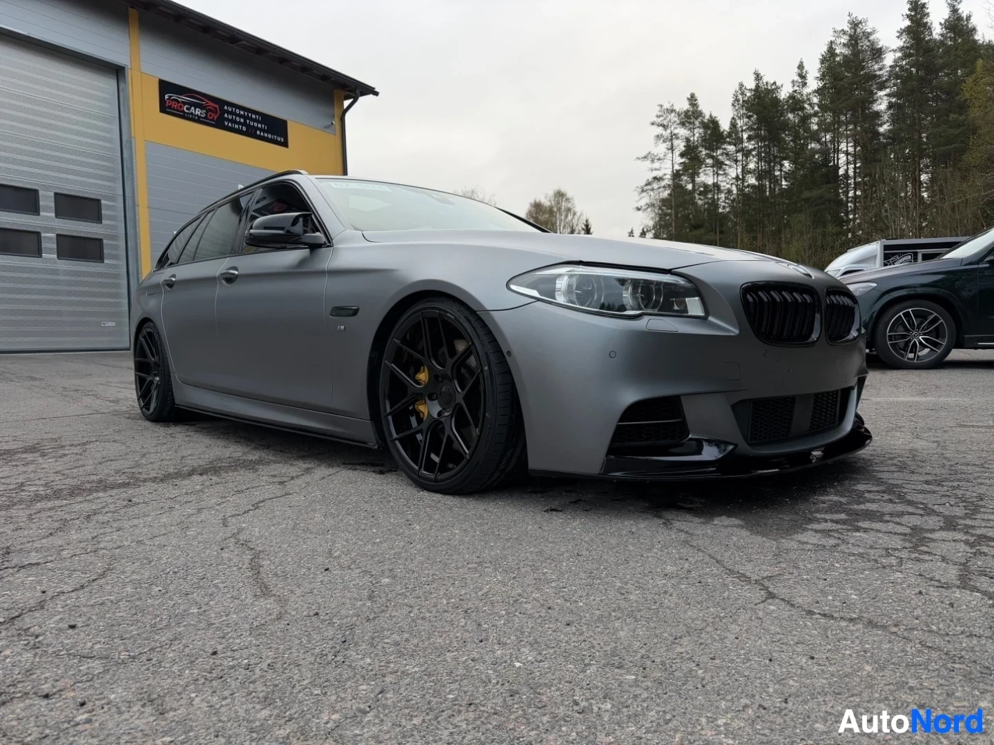 Silver BMW estate wagon shown from front-left angle with black wheels