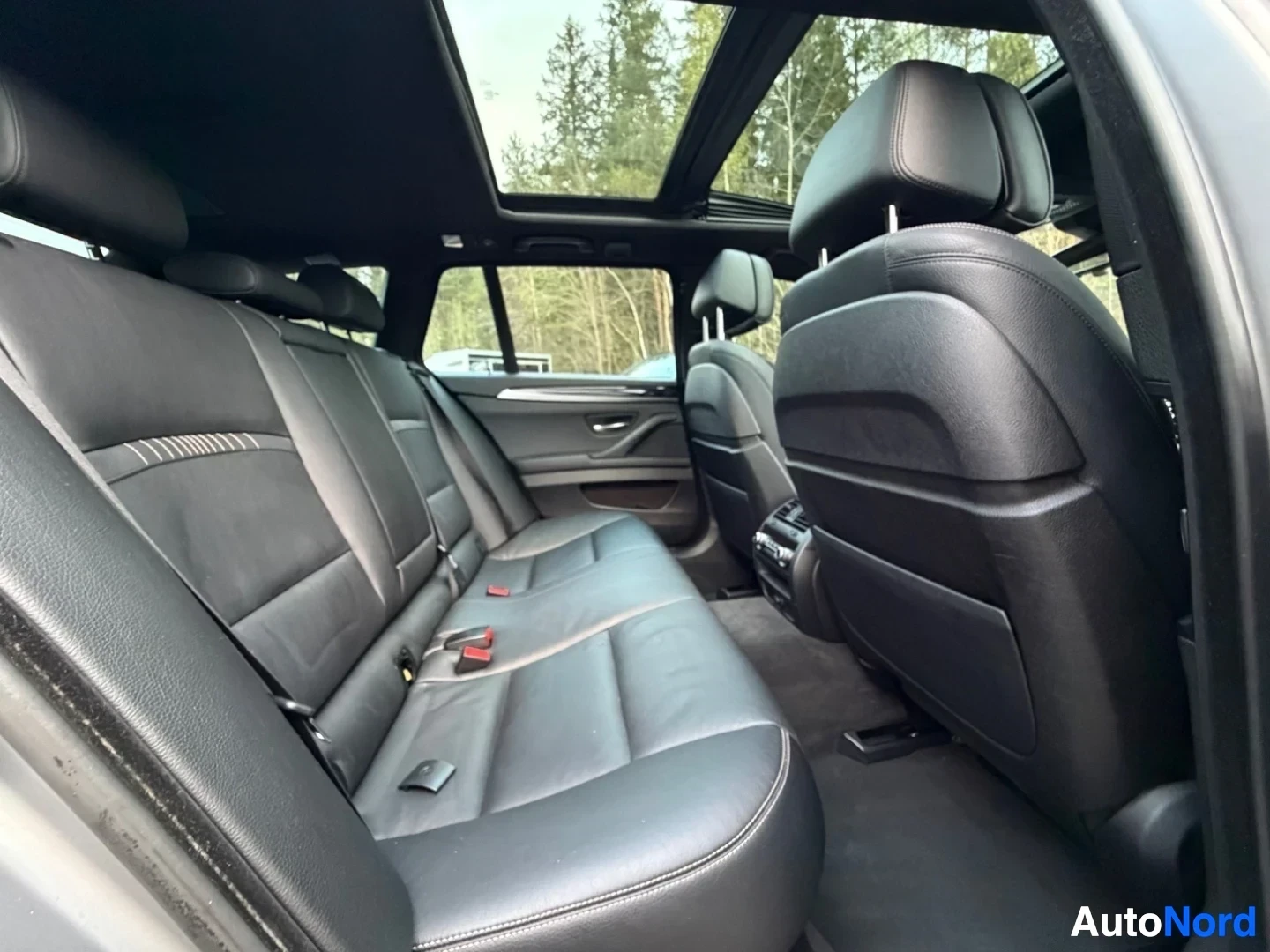 Rear seat interior with panoramic sunroof and leather seats visible