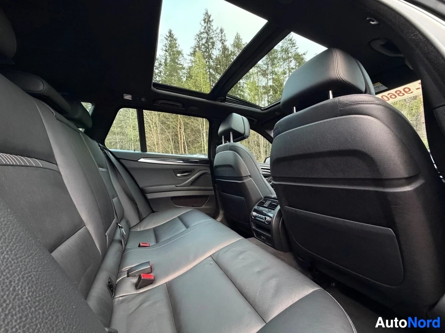 Rear passengers area with panoramic sunroof and black leather upholstery