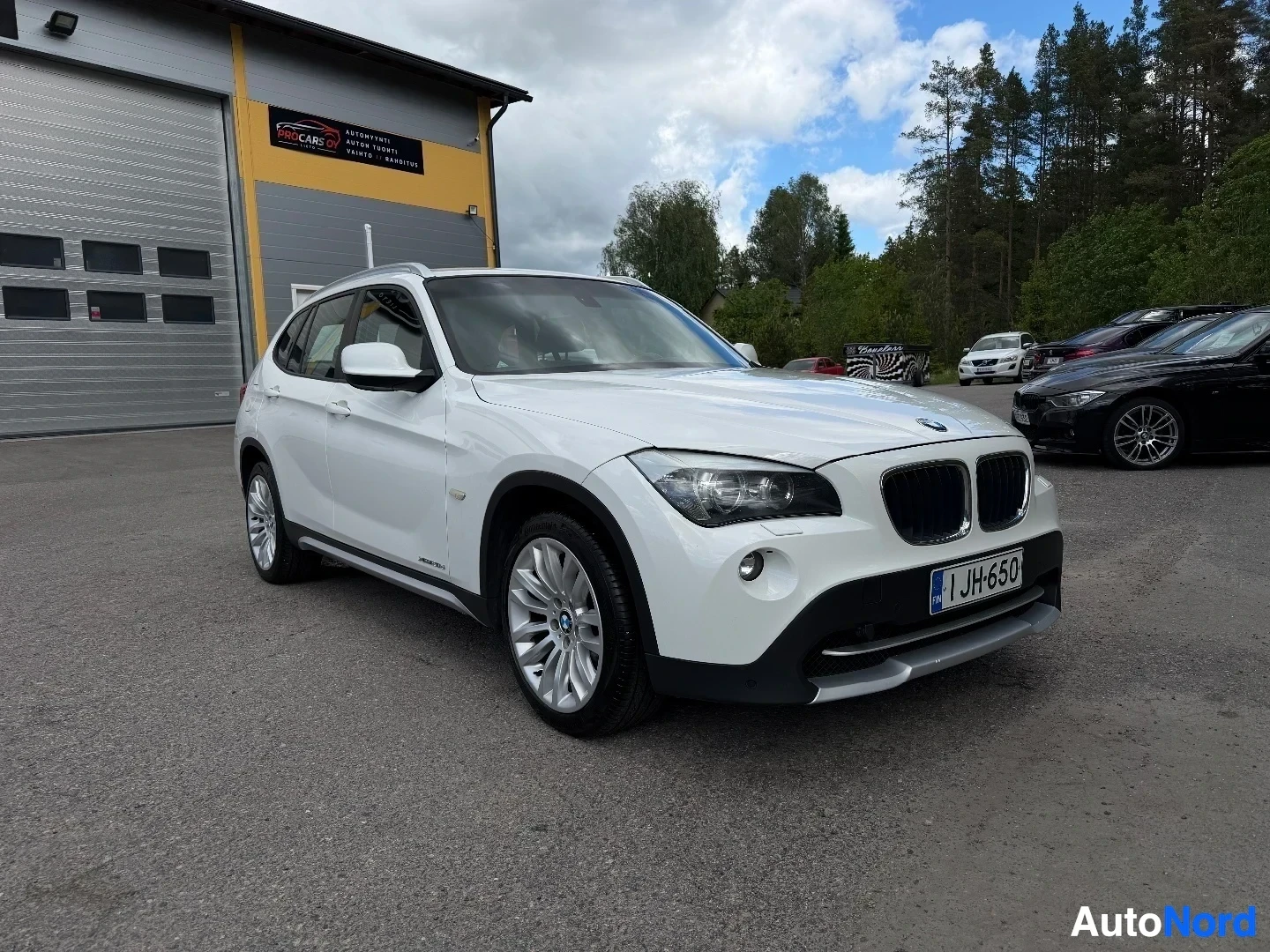White BMW X1 SUV front three-quarter view in dealer lot