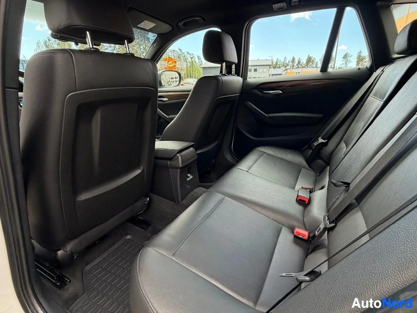Rear bench seat with black leather upholstery and headrests visible from side