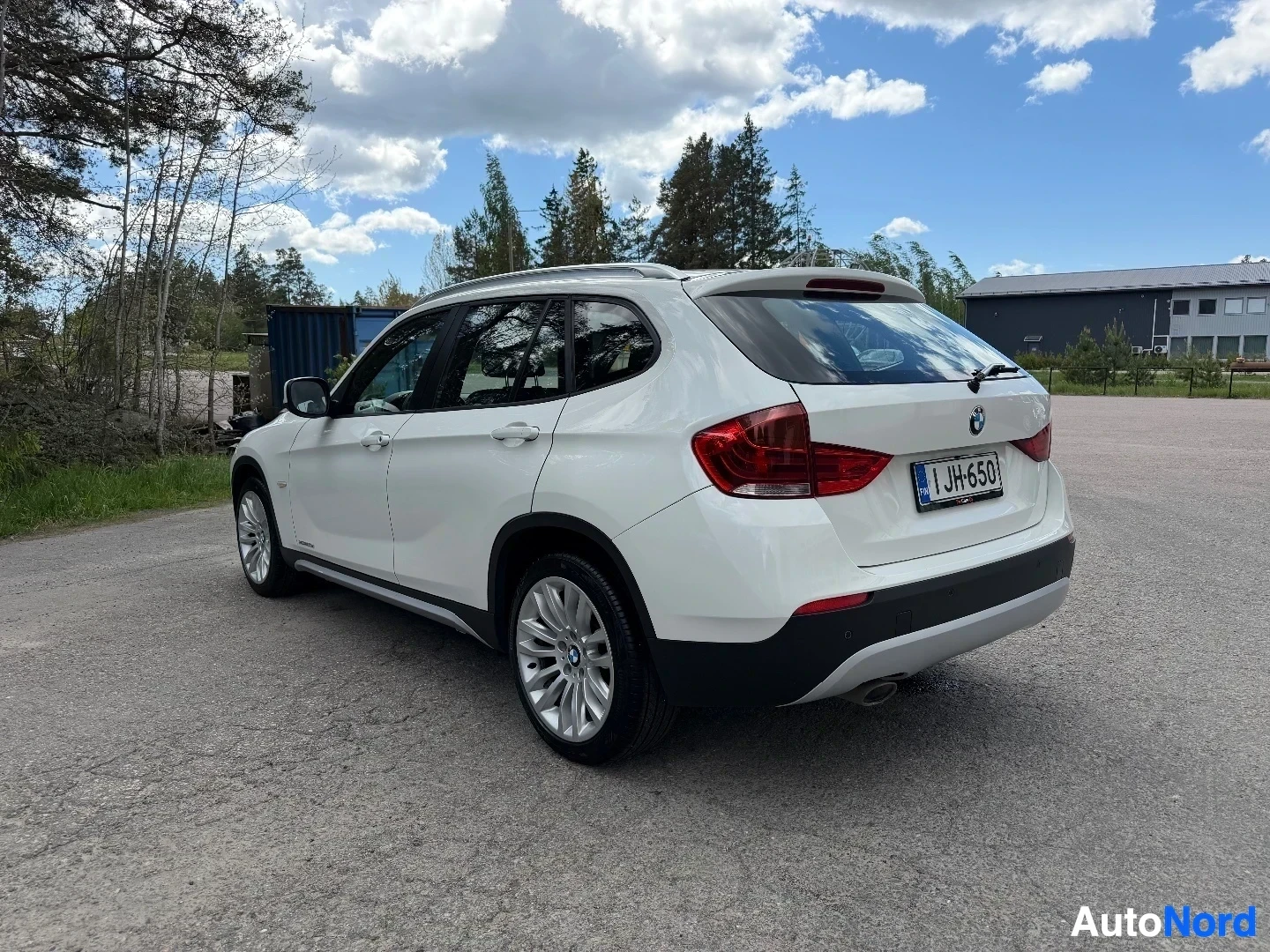 White BMW X1 SUV side profile view with open driver door
