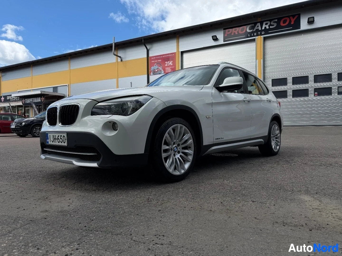 White BMW X1 front left angle view showing body lines and alloy wheels
