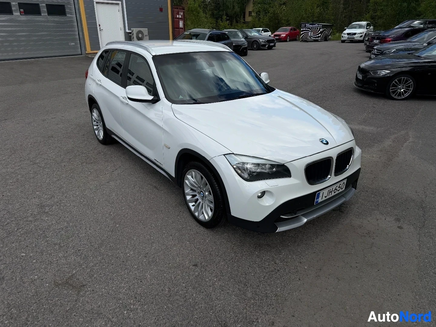 White BMW X1 SUV front view with dealer lot background