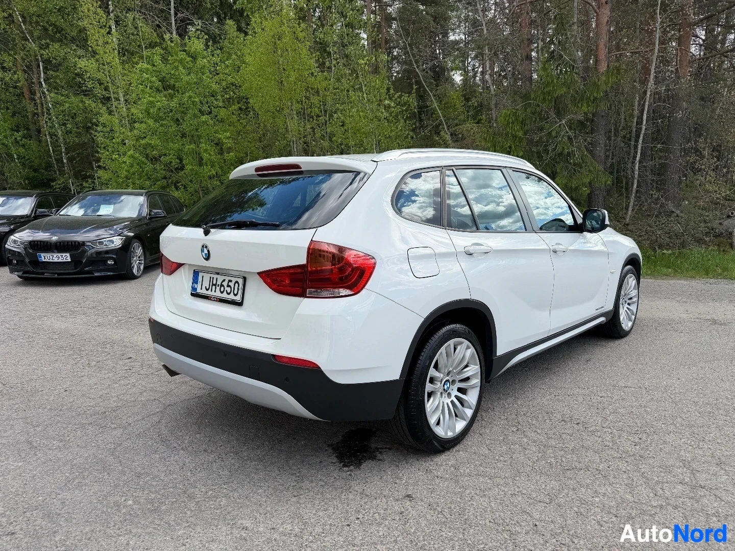 White BMW X1 SUV rear three-quarter view in parking lot