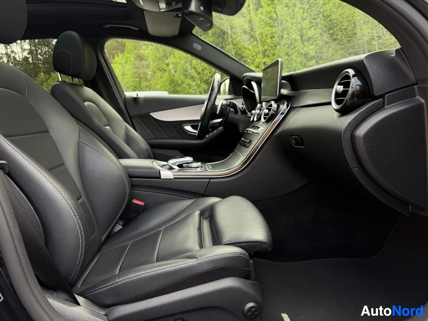 Interior side view showing front and rear black leather seats
