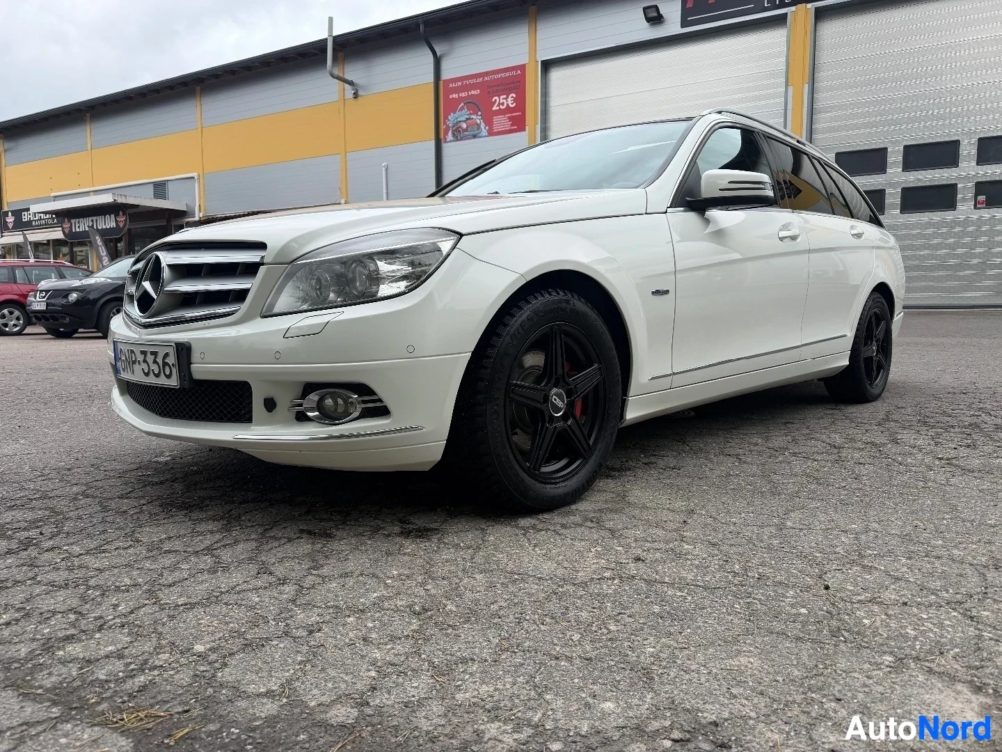 White Mercedes-Benz wagon viewed from front-left angle showing front grille and headlights