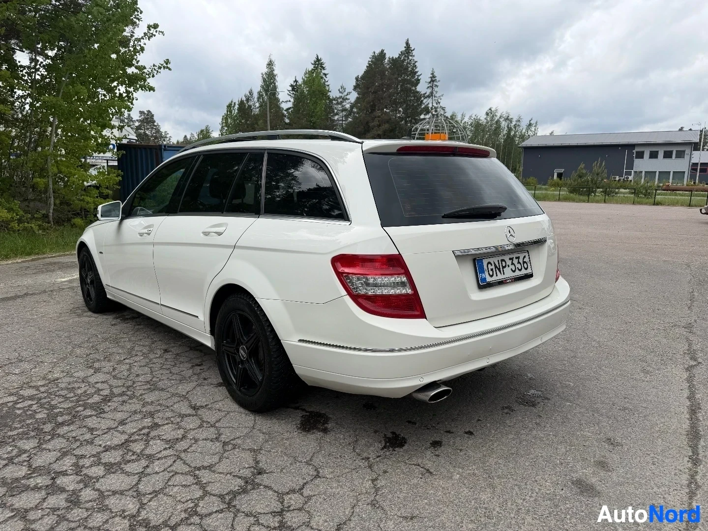White Mercedes-Benz wagon, full rear and side view in outdoor lot setting