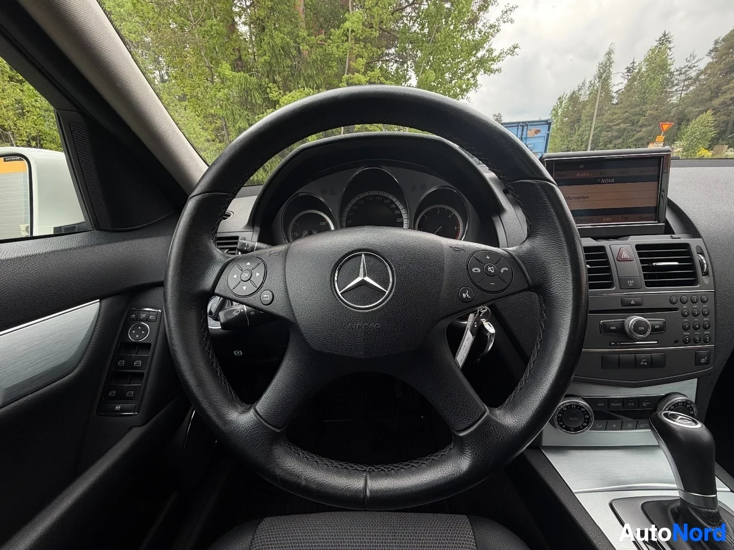 Ohjauspyörä lähikuvassa, Mercedes-Benz-logo ja mittaristo näkyvillä