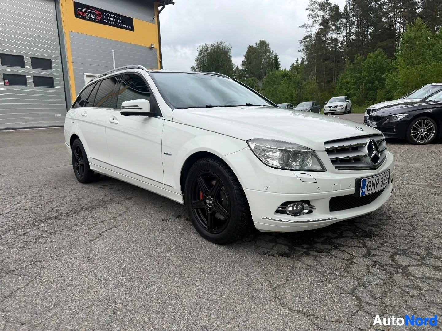 Valkoinen Mercedes-Benz farmari etupuolelta vasemmalta näkymällä