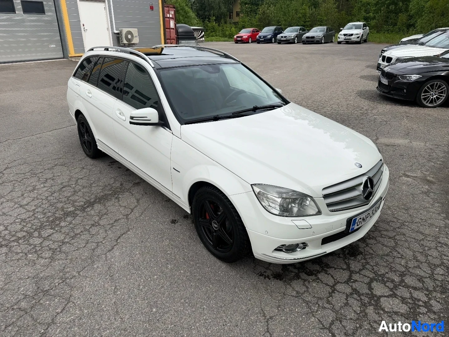 Valkoinen Mercedes-Benz farmari ylhäältä etukaartoon näkymällä